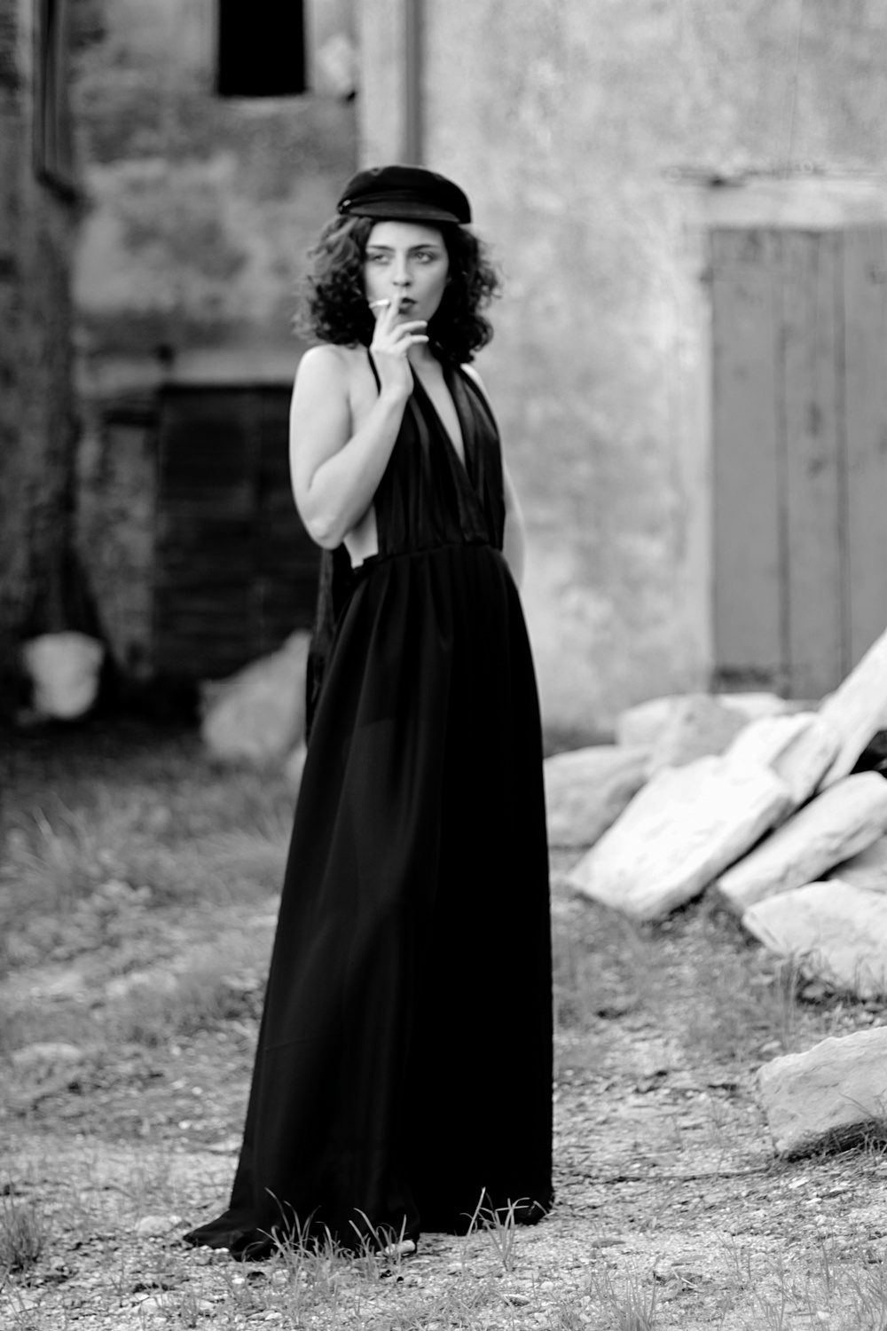 Ritratto in bianco e nero di ragazza con abito lungo da sera e sigaretta, fotografia analogica e vintage