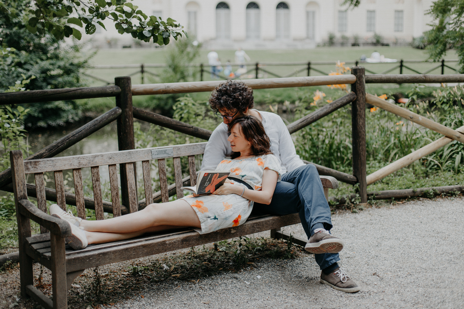 Coppia di fidanzati legge una dedica segnata su una panchina nel parco della GAM a Milano